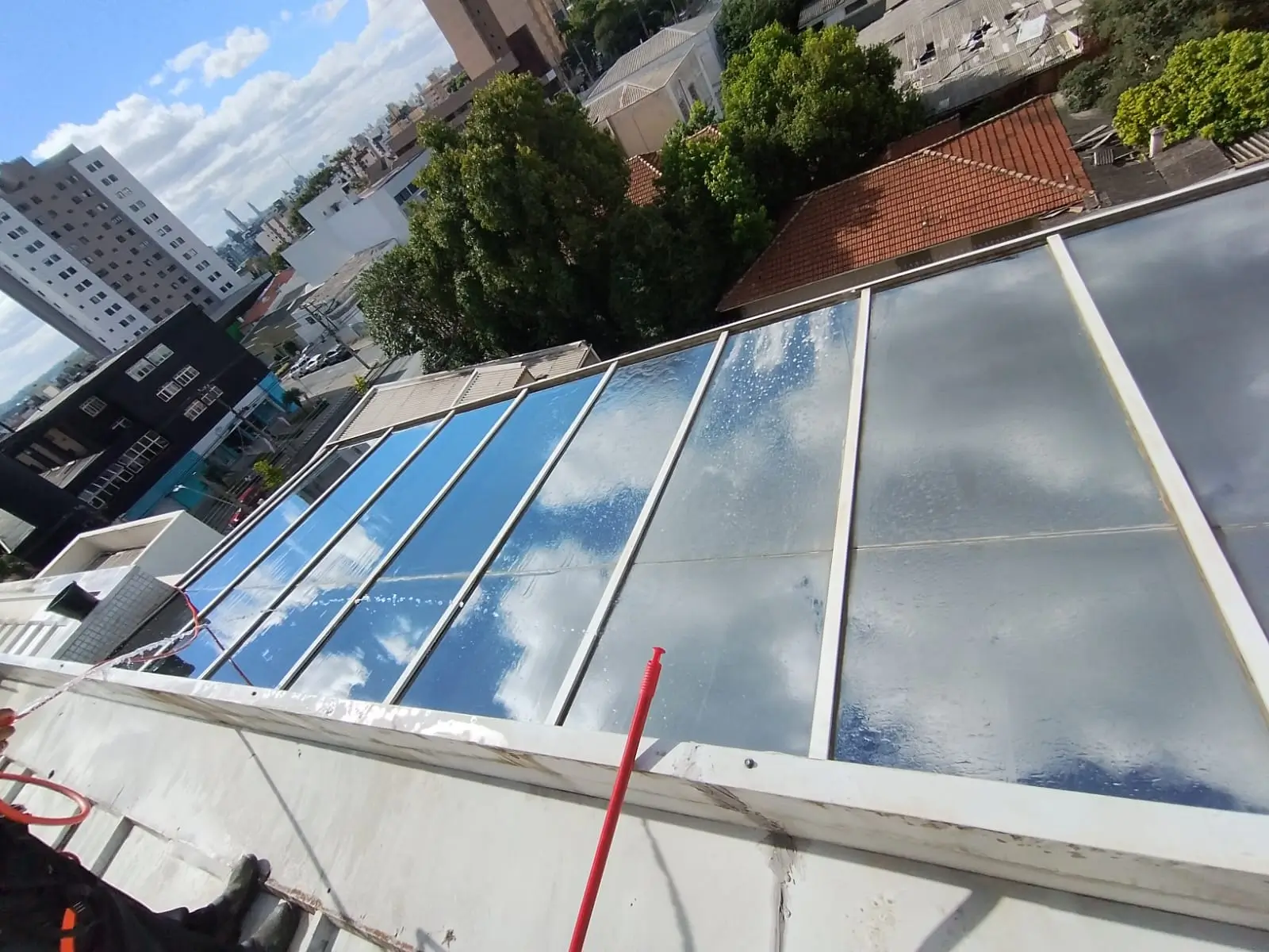 Profissional limpando vidros externos de edifício